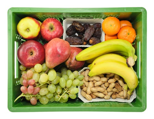 Grüne NAPF-Kiste gefüllt mit Obst, Datteln und Nüssen
